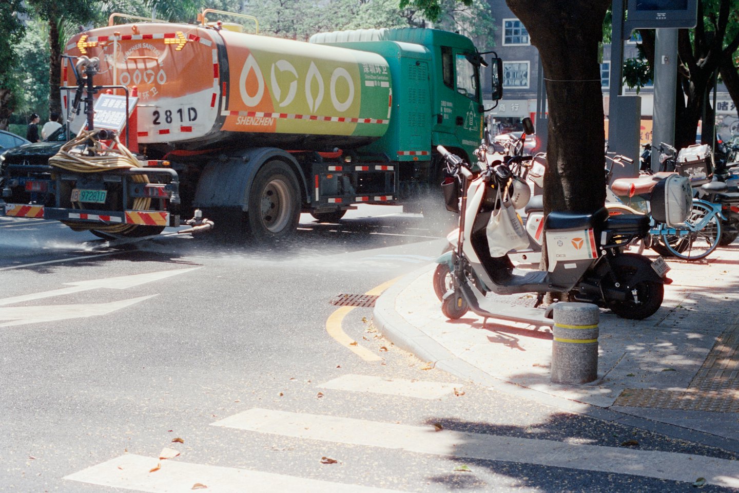 Un camion della nettezza urbana spruzza acqua su una strada cittadina.