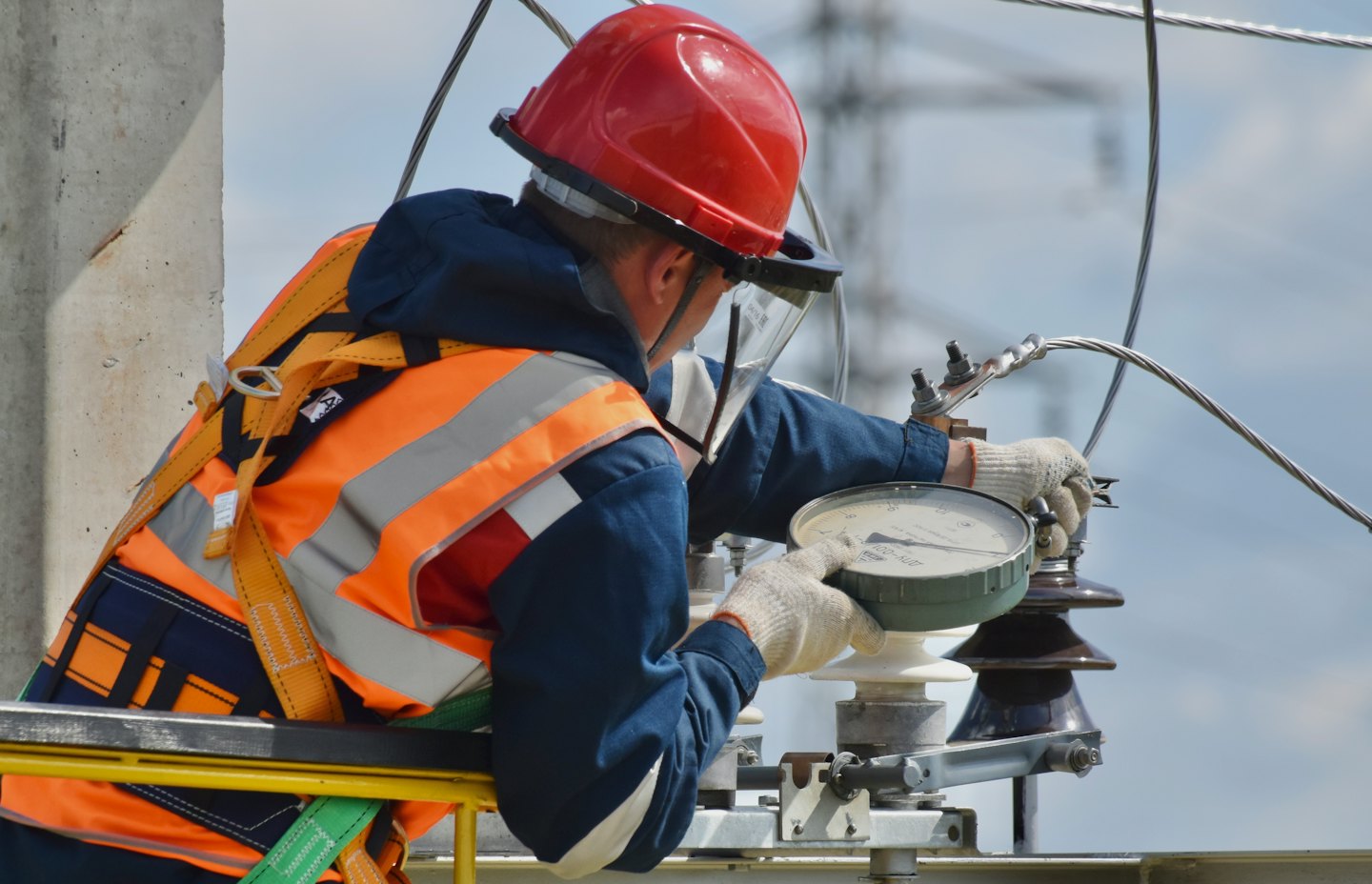 Tecnico con giubbotto di sicurezza regola apparecchiature elettriche all'aperto.