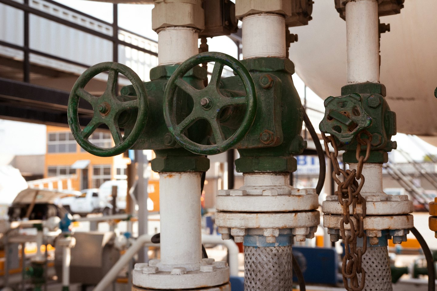 Valvole e tubi in metallo verde in un impianto idraulico industriale.